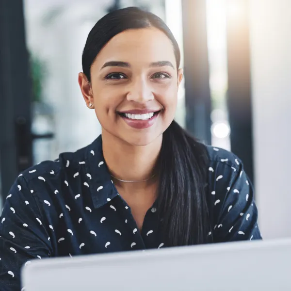 A smiling member of the Emplois Compétences team at her desk
