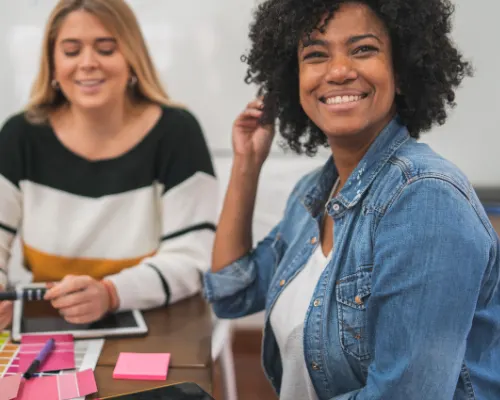 Deux employées souriantes à leur poste de travail